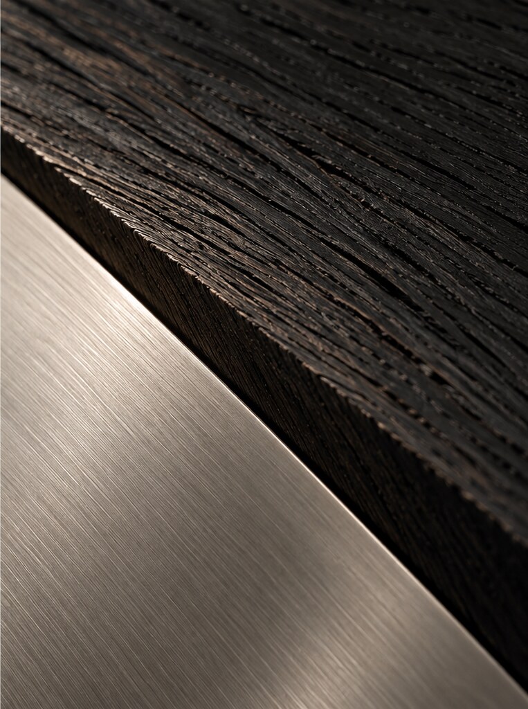Abstract material study of dark wood grain beside a brushed metal plane